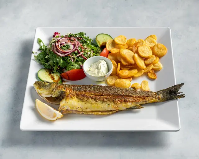 Ganzer Fisch vom Grill mit Zitrone, Kartoffelchips, Salat und Knoblauchdip