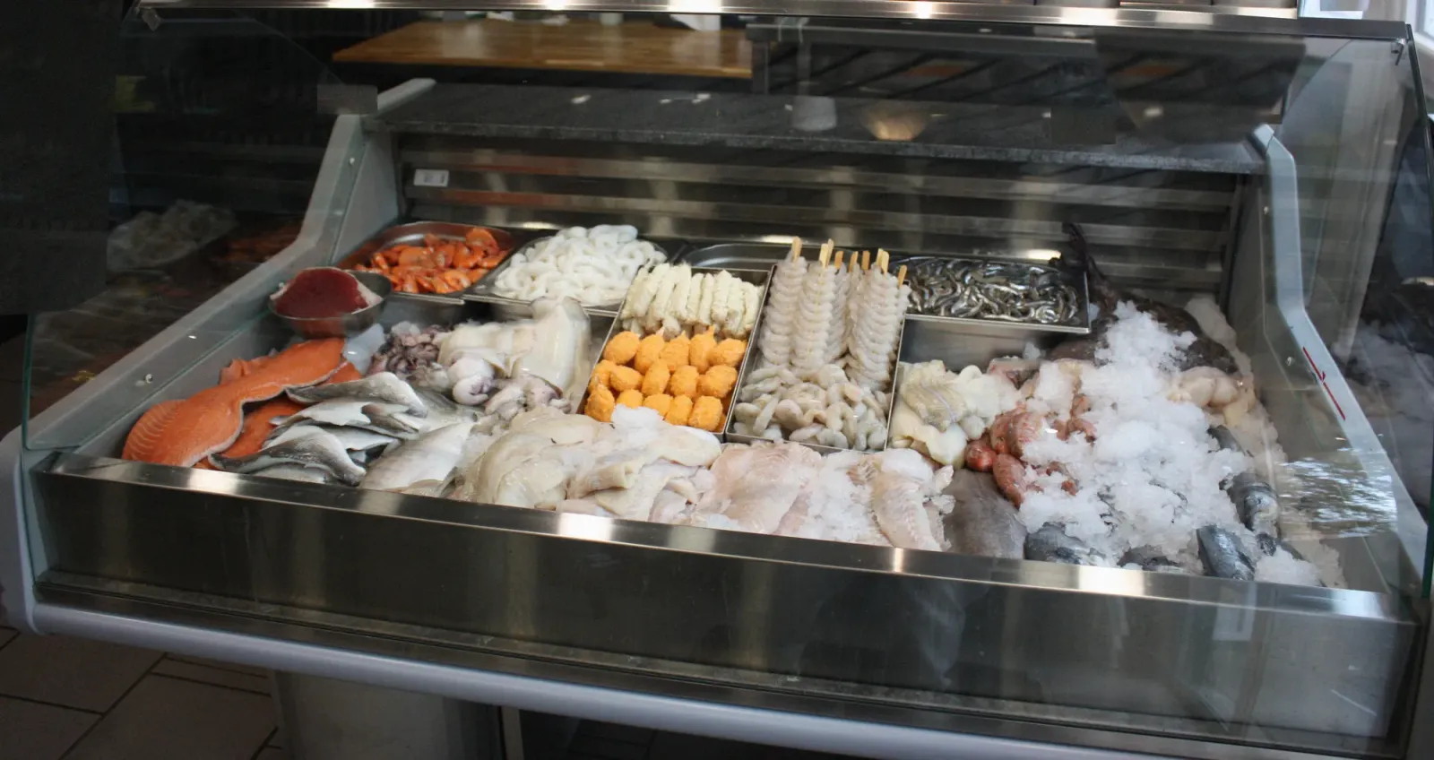 Die Fischtheke: frischer Fisch, Filets, Garnelen und Tintenfisch auf Eis